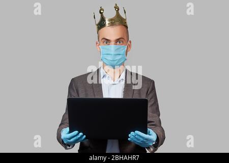Giovane uomo d'affari in corona e maschera facciale protettiva e guanti. Rimani a casa durante la quarantena del coronavirus Covid-19. Spazio vuoto per il testo. Foto Stock