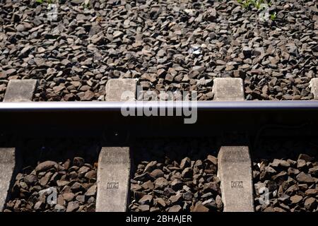 Vista dall'alto e primo piano su un binario ferroviario con rotaie e pietre di zavorra. Foto Stock