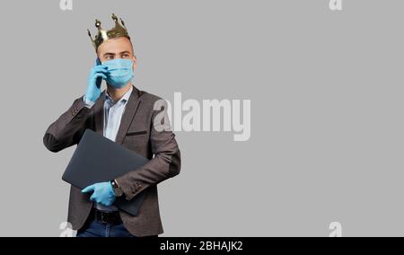 Giovane uomo d'affari in corona e maschera facciale protettiva e guanti. Rimani a casa durante la quarantena del coronavirus Covid-19. Spazio vuoto per il testo. Foto Stock