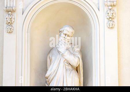 Una statua, un uomo che gli mette la mano in testa, al Gendarmenmarkt, tra la cupola francese e quella tedesca. Foto Stock