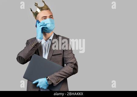 Giovane uomo d'affari in corona e maschera facciale protettiva e guanti. Rimani a casa durante la quarantena del coronavirus Covid-19. Spazio vuoto per il testo. Foto Stock
