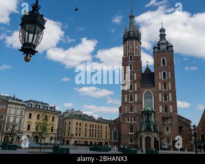 Cracovia/Polonia - 22/04/2020. Piazza principale quasi vuota a Cracovia durante la pandemia del coronavirus 19. Vista sulla chiesa di Mariacki. Foto Stock