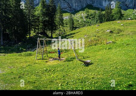 Europa, Germania, Baviera, Prealps bavaresi, Benediktbeuern, ragazzo che gioca con un altalena al Tutzinger Hütte Foto Stock