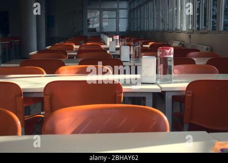 Primo piano di posti rossi vuoti di una caffetteria universitaria dopo la chiusura delle scuole Foto Stock