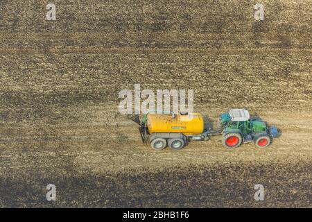 Vista aerea dello spruzzamento di concime con trattore su campi, Enkdorf, Meshede, Renania settentrionale-Vestfalia, Germania Foto Stock