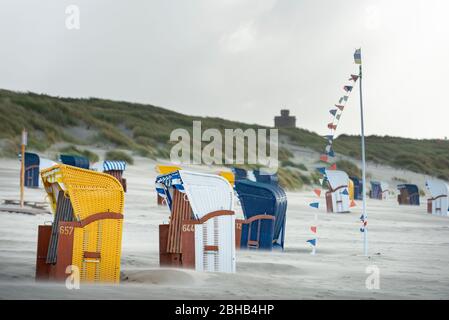 Germania, bassa Sassonia, Frisia Orientale, Juist, sedie da spiaggia nel vento. Foto Stock