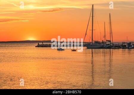 barche ormeggiate ad un piccolo porto turistico di vrsi molo al tramonto, vrsi, contea di zadar, dalmazia, croazia Foto Stock