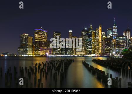Vista sull'Eastriver sulla silhouette del centro di Manhattan come una lunga esposizione notturna Foto Stock