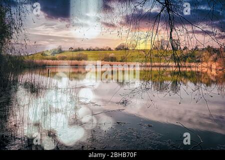 Uno stagno con erba accanto ad un corpo d'acqua Foto Stock