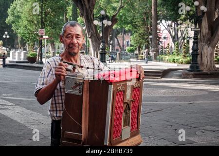 L'artista di strada di Organillero o Cilindrero, macinacarista di organi, suona l'organo di strada nello Zocalo di Puebla City durante lo scoppio del coronavirus, in Messico, nel 24 aprile 2020 Foto Stock