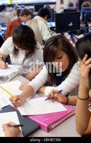 Carrolton Texas USA, 18 maggio 2009. Le studentesse si aiutano a vicenda con risposte a quiz presso la Math, Engineering, Technology and Science Academy (METSA) di R.L. Turner High School nel Farmers Branch/Carrollton School District a Dallas. Gli studenti di METSA imparano attraverso attività di apprendimento attive basate su progetti, esperienze sul campo, mostre senior e stage. ©Bob Daemmrich Foto Stock