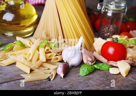 Pasta con pomodori ciliegini e altri ingredienti su sfondo ligneo Foto Stock