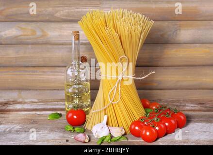 Pasta con pomodori ciliegini e altri ingredienti su sfondo ligneo Foto Stock