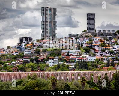 Il vecchio e il nuovo si combinano a Queretaro, Messico, come alti edifici di appartamenti salgono vicino all'acquedotto coloniale. Foto Stock