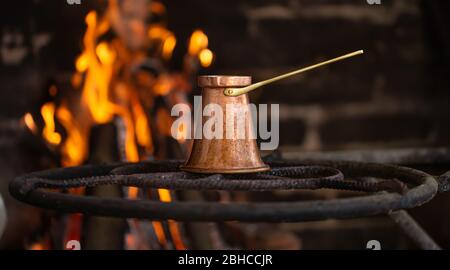 Preparare il caffè in un Turco a fuoco aperto . Foto Stock