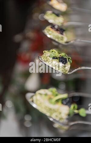 Gustosi piatti di tartine in linea appesi con antipasti di caviale e formaggio cremoso, isolati su sfondo bianco, spuntini finger food durante il brunch dell'hotel Foto Stock