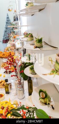 Gustosi piatti di tartine in linea appesi con antipasti di caviale e formaggio cremoso, isolati su sfondo bianco, spuntini finger food durante il brunch dell'hotel Foto Stock