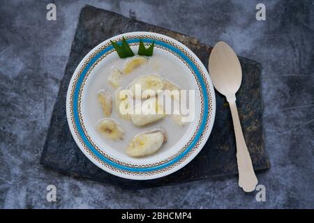 Indonesiano cibo Kolak Pisang / Banana Compoe. A base di banana cotta con latte di cocco, zucchero di palma e foglie di pandano. Molto pop Foto Stock