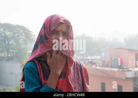 donna che copre il suo viso con saree come maschera Foto Stock