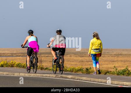 Southport, Merseyside, Regno Unito. 25 Aprile 2020. Distanza sociale nel resort come residenti locali prendere luce esercizio sul sentiero costiero Ribble Estuario RSPB Reserve. Un sondaggio locale ha suggerito che recentemente sono state contate sulla spiaggia fino a 720 persone nel corso di un giorno. Credit: MediaWorldImages/AlamyLive News. Foto Stock