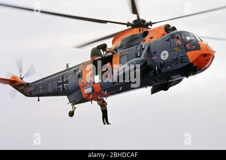 Sar Helicopter della Marina tedesca che raccoglie l'ispettore della Marina, Ansgar Bethge, e scorta alla nave da addestramento Deutschland, 26 maggio 1982, Mar Baltico, Germania Foto Stock