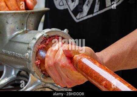 Tritare il maiale in budello per fare salsicce italiane essiccate Foto Stock