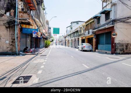 L'auto d'argento è in esecuzione sulla strada e due donne stanno camminando accanto alla strada senza marciapiede a Bangkok, Thailandia 14 aprile 2018 Foto Stock