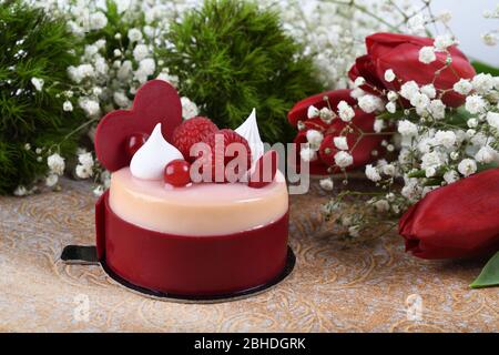 Mini torta alla vaniglia di lamponi dai colori vivaci, festa dell'amore, festa. Dessert di macaroon fresco e lussuoso a forma di cuore. Anniversario di festa mangiare. Madre Foto Stock