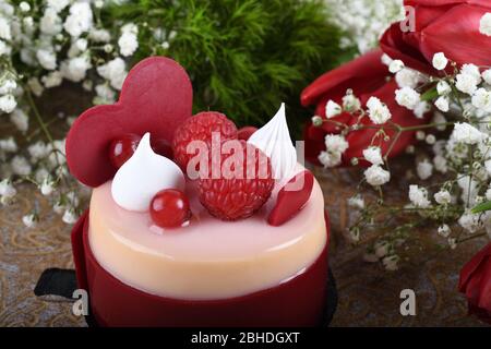 Mini torta alla vaniglia di lamponi dai colori vivaci, festa dell'amore, festa. Dessert di macaroon fresco e lussuoso a forma di cuore. Anniversario di festa mangiare. Madre Foto Stock