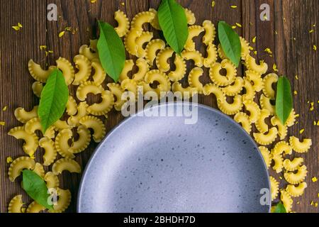 Pene lisce a forma di mese su un piatto grigio su sfondo di legno scuro. Viste superiori Foto Stock