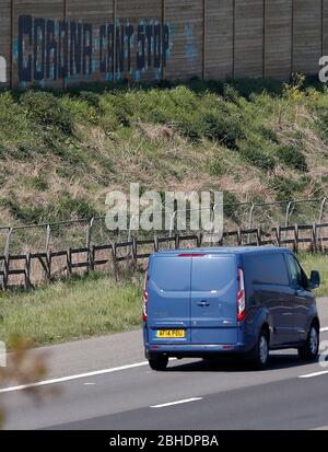 Shepshed, Leicestershire, Regno Unito. 25 aprile 2020. Un furgone passa graffiti dipinti su recinzioni accanto all'autostrada M1 durante la chiusura pandemica del coronavirus. Credit Darren Staples/Alamy Live News. Foto Stock