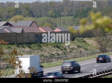 Shepshed, Leicestershire, Regno Unito. 25 aprile 2020. I veicoli passano graffiti dipinti sulla recinzione accanto all'autostrada M1 durante la chiusura a chiave della pandemia di coronavirus. Credit Darren Staples/Alamy Live News. Foto Stock