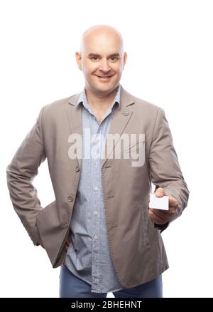 Un uomo calvo in un vestito beige mostra una scheda da visita isolata su bianco. Foto Stock