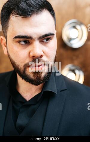 giovane uomo elegante e serio con barba che indossa abiti formali Foto Stock