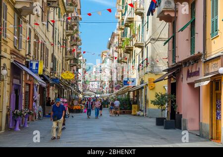 La Spezia, Italia, 13 settembre 2018: Persone che camminano lungo la strada pedonale principale con le bandiere sopra nel centro storico della città in estate, Liguria Foto Stock