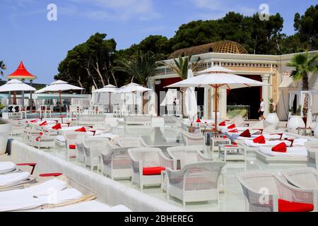 Bella vista pittoresca sulla spiaggia, ombrelloni presso la lussuosa piscina. Sedie e lettini bianchi alla moda, mobili da spiaggia sul mare Foto Stock