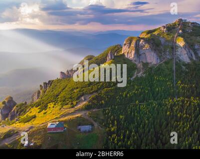 Vista aerea dello chalet di montagna e delle scale di picco al tramonto nei Carpazi rumeni. Foto Stock