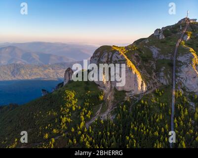 Cima rocciosa aerea e scale di accesso al massiccio di Ceahlau, Carpazi rumeni Foto Stock