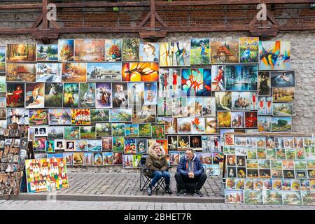 Artisti di strada che vendono pittingsat porta di San Florian a Cracovia, Polonia Foto Stock