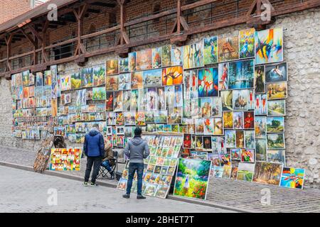 Artisti di strada che vendono pittingsat porta di San Florian a Cracovia, Polonia Foto Stock