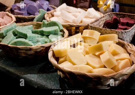 Saponi colorati su una bancarella di mercato con cestini Foto Stock