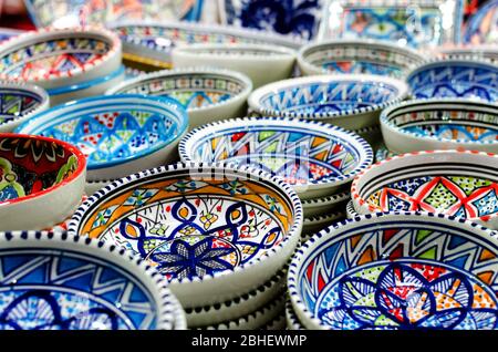 Molte piastre tradizionali asiatiche in porcellana dipinte a mano su una bancarella del mercato Foto Stock