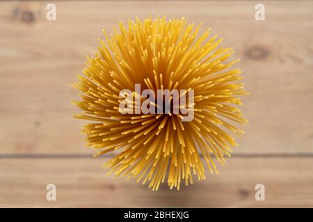 Fila, spaghetti non cotti accatastati insieme. Pasta o maccheroni italiani. Uccello occhio, vista dall'alto, tavolo sfondo in legno. Prodotti di pasta secca. Foto Stock