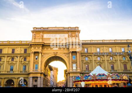 Firenze, 15 settembre 2018: Arco tra edifici e giostra vintage in Piazza della Repubblica nel centro storico della città, cielo blu nuvole bianche, Toscana Foto Stock