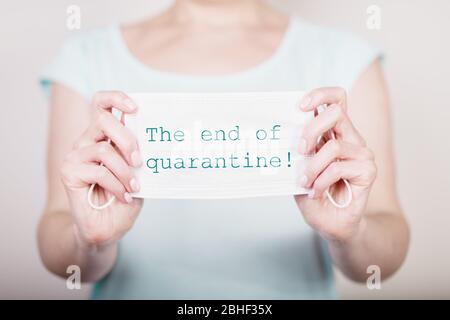 Concetto di arresto della quarantena per coronavirus. Le mani femminili trattengono la maschera medica bianca con l'iscrizione Foto Stock