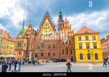Wroclaw, Polonia, 7 maggio 2019: Edificio del vecchio Municipio con torre dell'orologio guglia e folla di turisti molte persone sulla piazza del mercato Rynek acciottolato nel centro storico della città vecchia Foto Stock