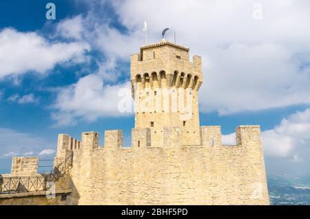 Repubblica San Marino, 18 settembre 2018: Seconda Torre la testa seconda torre fortificata con merli e muri in mattoni su roccia di pietra del Monte Titano, cielo blu bianco nuvole sfondo Foto Stock