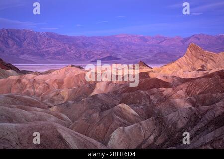 I badlands di Zabriskie Point, il bacino di Badwater e le montagne Panamint; il Parco Nazionale della Death Valley, California. Foto Stock