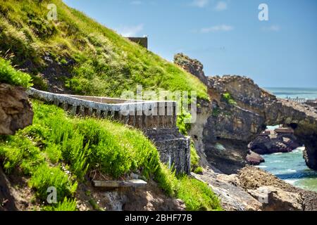 Biarritz, Francia. Costa dell'oceano Atlantico. Recinto di pietra vecchio sul pendio di collina verde. Giornata estiva soleggiata. Città turistica francese Foto Stock