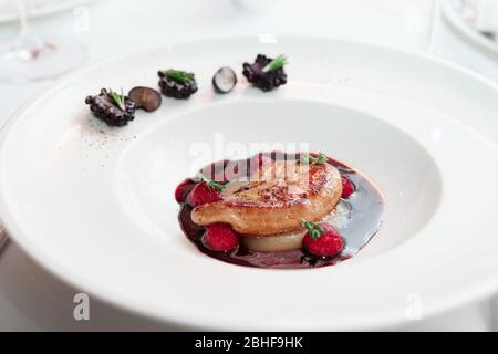 Foie gras con salsa di porto su piatto bianco, alta cucina, primo piano Foto Stock